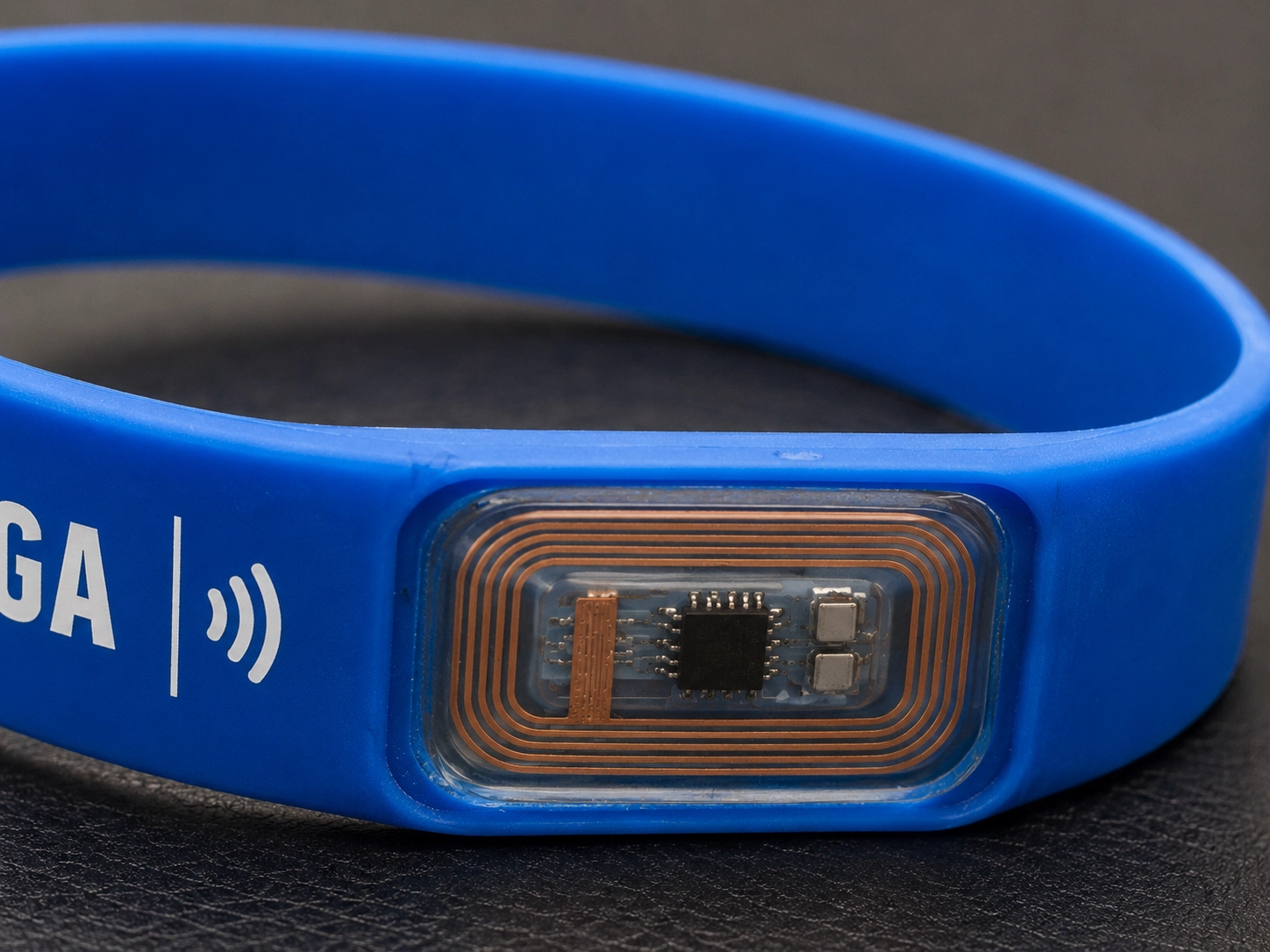 Close-up of a high-tech RFID chip embedded in a silicone wristband, highlighting the carbon footprint and long-term sustainability factors of silicone production Close-up of a high-tech RFID chip embedded in a silicone wristband, highlighting the carbon footprint and long-term sustainability factors of silicone production